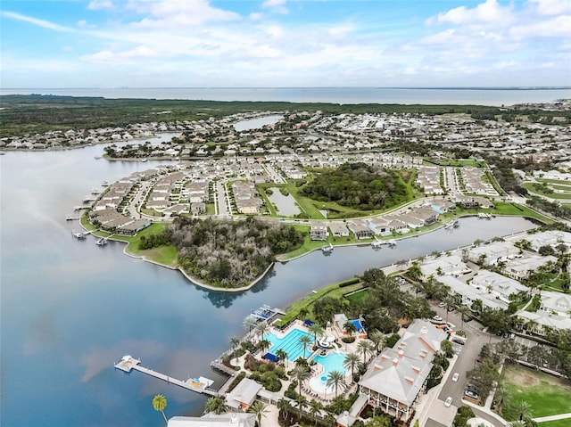 aerial view of property's location featuring a nearby body of water, a pool area, and nearby suburban area