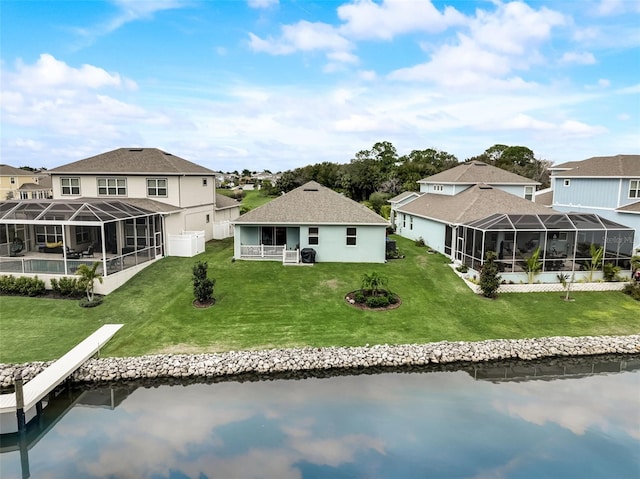 back of property with a lawn, a water view, and a residential view