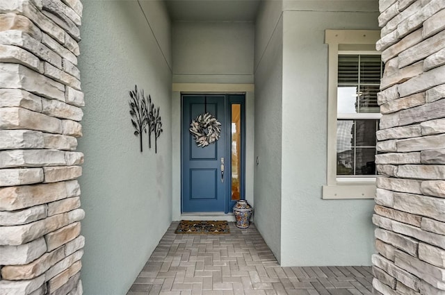 view of exterior entry featuring stucco siding