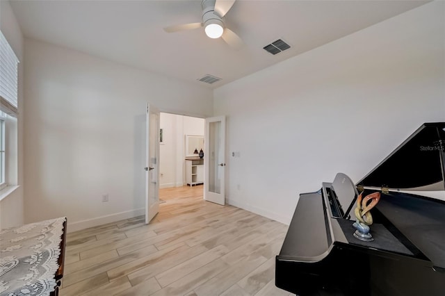 office featuring light wood-type flooring, a ceiling fan, and baseboards
