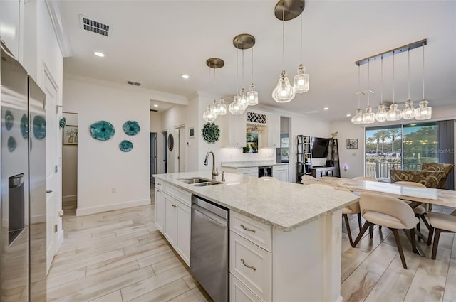 kitchen featuring a sink, dishwasher, white cabinetry, crown molding, and light stone countertops