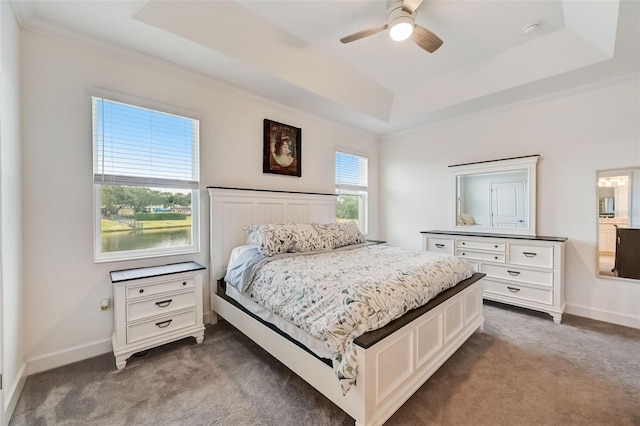 carpeted bedroom with a raised ceiling, baseboards, crown molding, and ceiling fan
