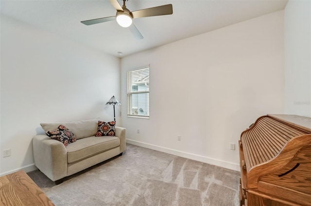 sitting room with baseboards, ceiling fan, and carpet