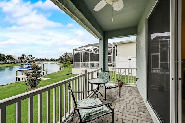 balcony featuring a water view, a sunroom, and a ceiling fan