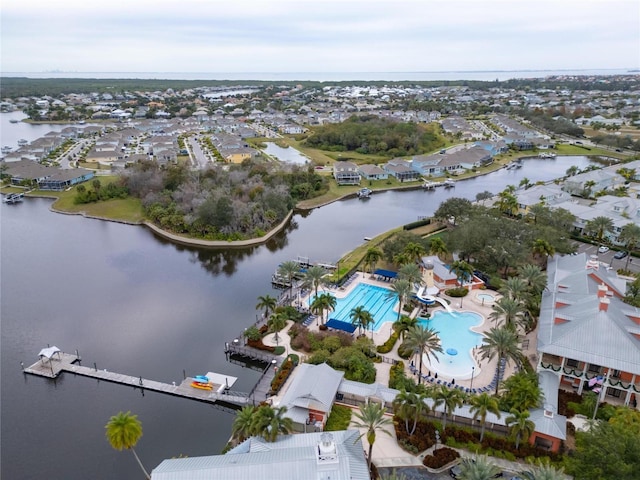 aerial perspective of suburban area featuring a large body of water and a pool area