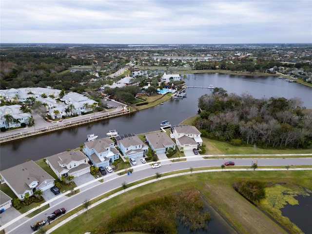 aerial view of property and surrounding area featuring nearby suburban area and a large body of water