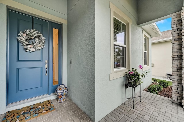doorway to property featuring stucco siding