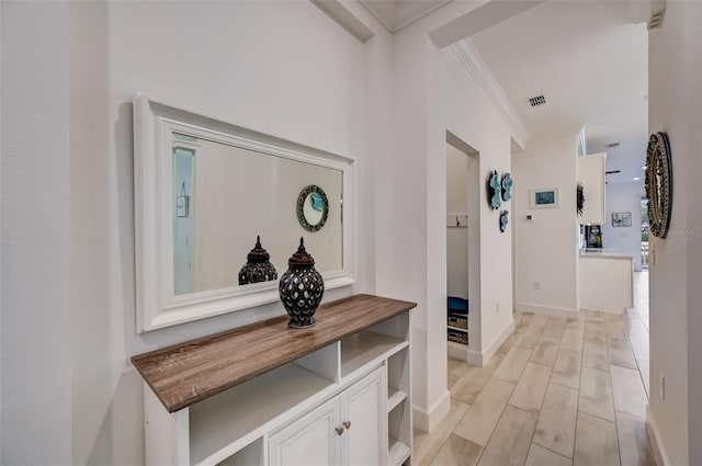 corridor with crown molding and baseboards