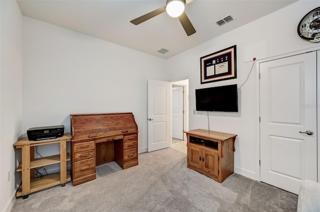 office space with light colored carpet, ceiling fan, and baseboards