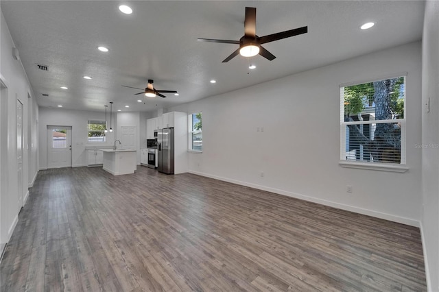 6097 Vermont Ave, New Port Richey, FL 34653 - unfurnished living room featuring a ceiling fan, recessed lighting, wood finished floors, and baseboards