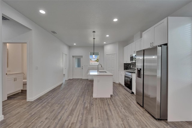 6097 Vermont Ave, New Port Richey, FL 34653 - kitchen featuring stainless steel appliances, a sink, white cabinets, light wood-style floors, and recessed lighting