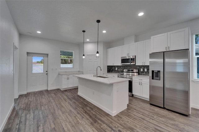 6097 Vermont Ave, New Port Richey, FL 34653 - kitchen featuring appliances with stainless steel finishes, a sink, wood finished floors, white cabinets, and recessed lighting