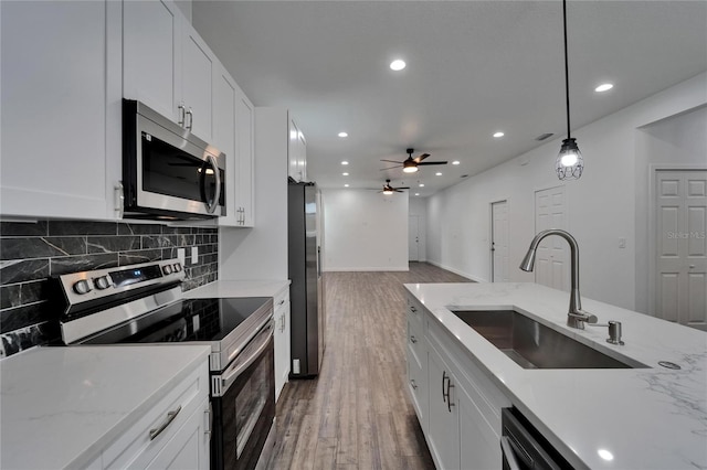 6097 Vermont Ave, New Port Richey, FL 34653 - kitchen with stainless steel appliances, a sink, tasteful backsplash, white cabinetry, and ceiling fan