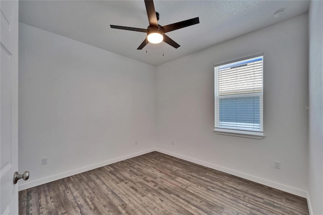 6097 Vermont Ave, New Port Richey, FL 34653 - empty room with wood finished floors, ceiling fan, baseboards, and a smoke detector