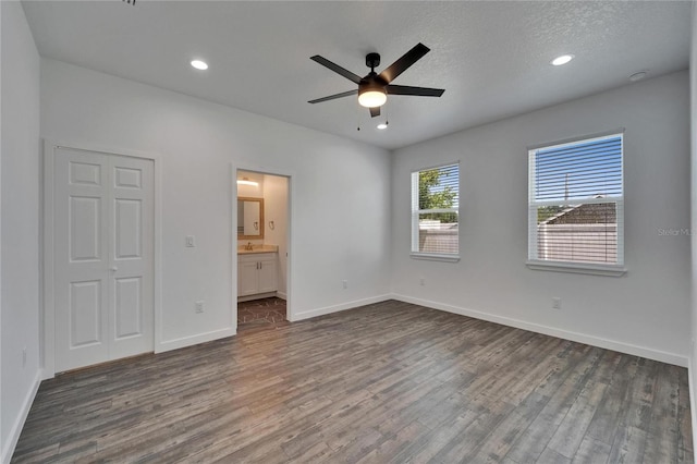 6097 Vermont Ave, New Port Richey, FL 34653 - unfurnished bedroom with dark wood finished floors, baseboards, recessed lighting, ensuite bathroom, and ceiling fan