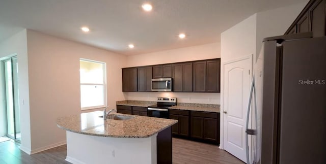 5407 Kedgewick Ln, North Port, FL 34288 - kitchen with appliances with stainless steel finishes, a sink, dark brown cabinets, light wood-type flooring, and recessed lighting
