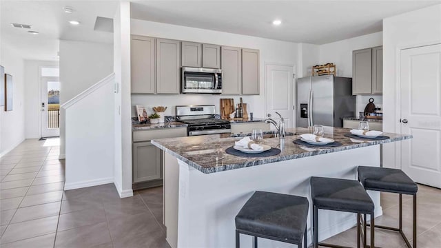 36123 Sunflower Hill Dr, Zephyrhills, FL 33541 - kitchen with stainless steel appliances, gray cabinetry, a sink, a kitchen breakfast bar, and recessed lighting