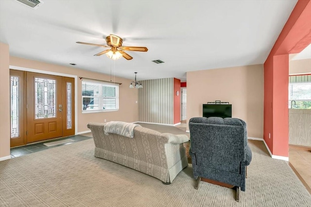 1666 Souvenir Dr, Clearwater, FL 33755 - carpeted living room featuring healthy amount of natural light, baseboards, and ceiling fan