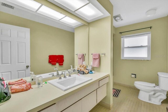 1666 Souvenir Dr, Clearwater, FL 33755 - bathroom featuring toilet, vanity, tile patterned flooring, and baseboards