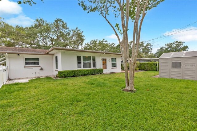 1666 Souvenir Dr, Clearwater, FL 33755 - back of property with stucco siding, a storage unit, and an outbuilding