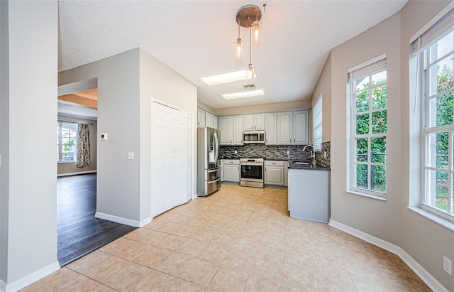 1712 Crossvine Ct, Trinity, FL 34655 - kitchen featuring appliances with stainless steel finishes, dark countertops, plenty of natural light, backsplash, and a textured ceiling