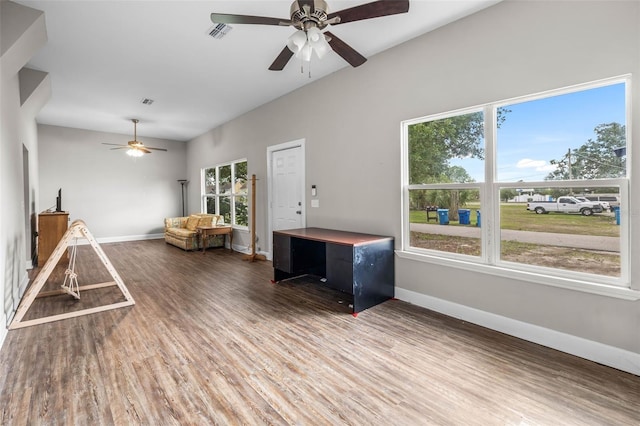living area with a ceiling fan, baseboards, wood finished floors, and lofted ceiling