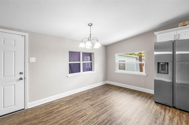 unfurnished dining area with dark wood-style floors, a chandelier, and baseboards