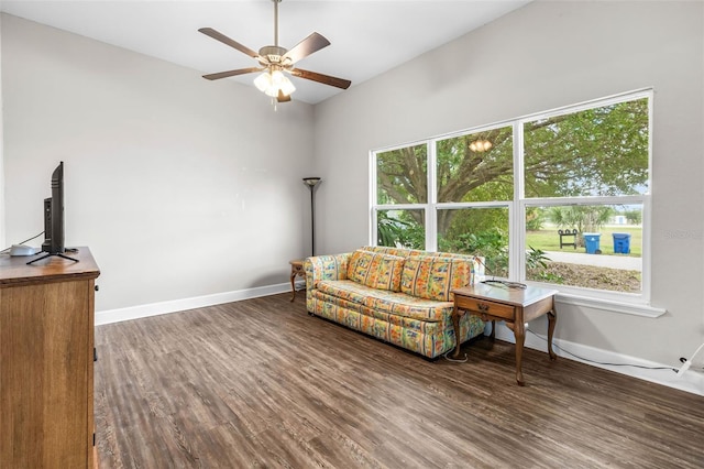 living area featuring wood finished floors, ceiling fan, baseboards, and lofted ceiling