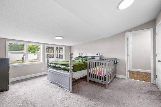 bedroom with carpet floors, baseboards, and lofted ceiling
