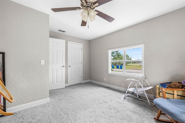 unfurnished room with carpet flooring, baseboards, a textured wall, and a ceiling fan