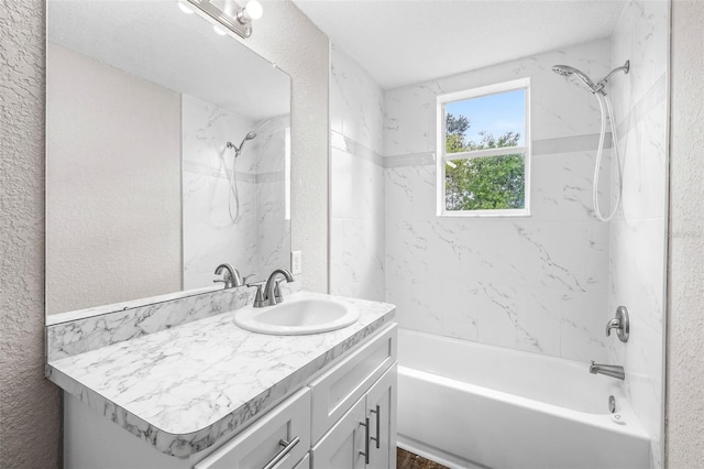 full bathroom with a textured wall, shower / tub combination, and vanity