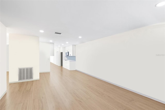6025 Shore Blvd S Unit 409, Gulfport, FL 33707 - unfurnished living room featuring light wood-style flooring and recessed lighting