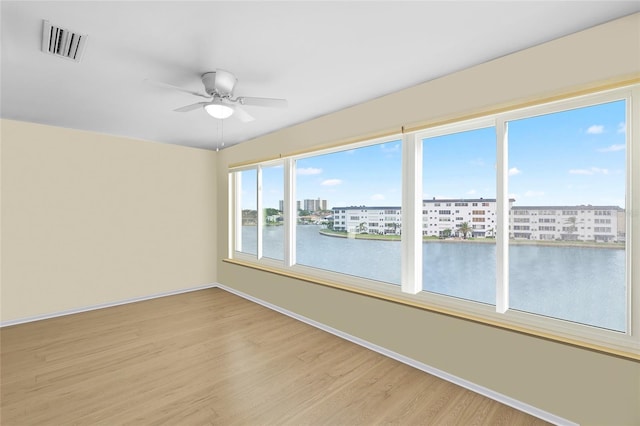 6025 Shore Blvd S Unit 409, Gulfport, FL 33707 - unfurnished room with light wood finished floors, a ceiling fan, baseboards, a water view, and a view of city