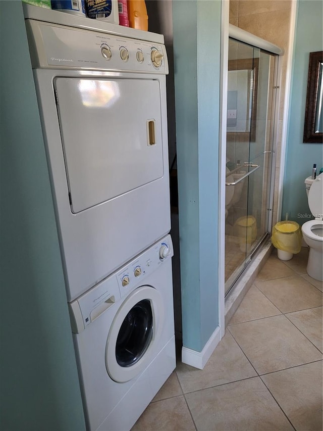17960 Gulf Blvd Unit 101, Redington Shores, FL 33708 - laundry room featuring estacked washer and dryer, light tile patterned flooring, and baseboards