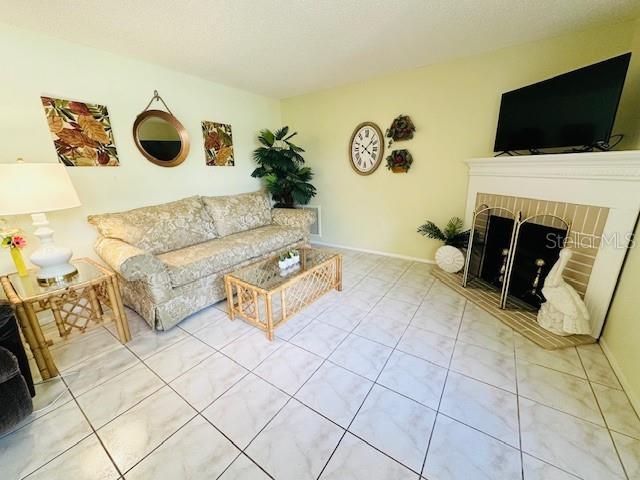 living room with tile patterned floors and a fireplace