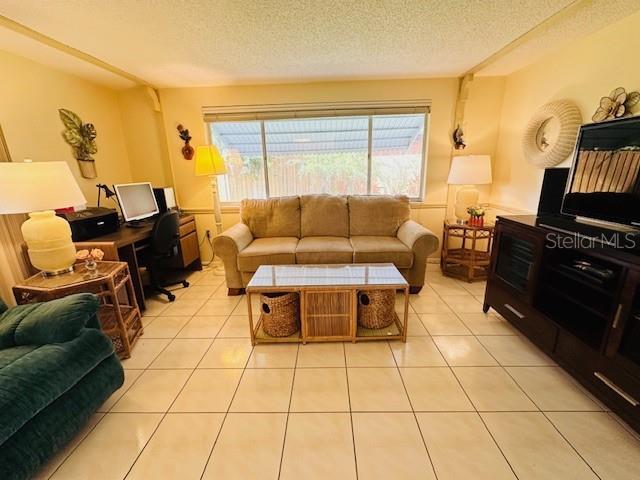 living area with a textured ceiling and light tile patterned floors
