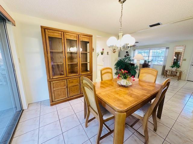 dining room with a chandelier and light tile patterned floors