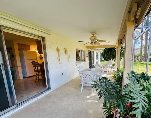 sunroom featuring ceiling fan, plenty of natural light, and outdoor dining area