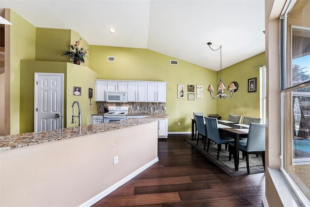 14042 Marlberry Way, Odessa, FL 33556 - kitchen with white appliances, dark wood-style floors, white cabinetry, a chandelier, and lofted ceiling