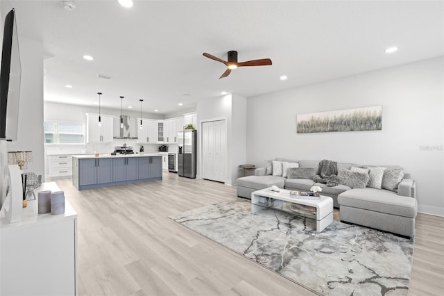 living room with ceiling fan, light wood-style floors, and recessed lighting