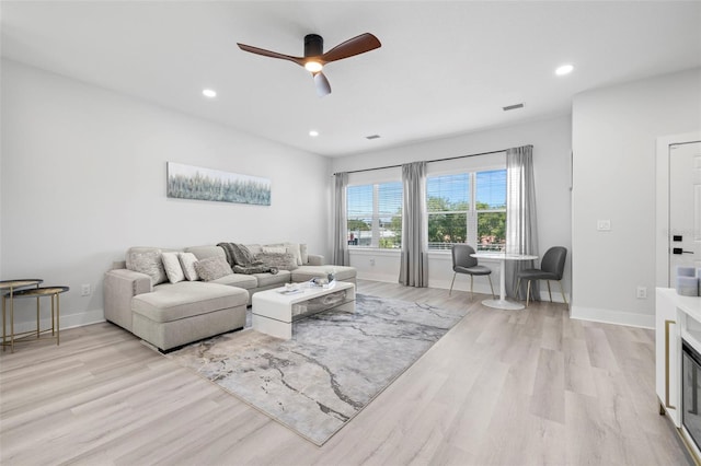 living room with light wood-style flooring, a ceiling fan, baseboards, and recessed lighting