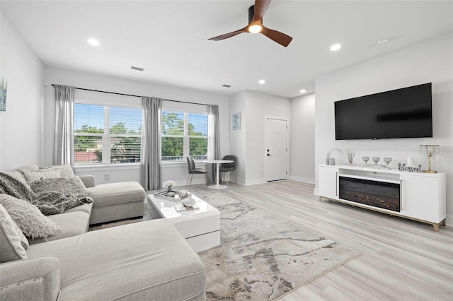 living area with wood finished floors, ceiling fan, recessed lighting, and baseboards