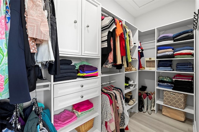 walk in closet featuring wood finished floors and attic access