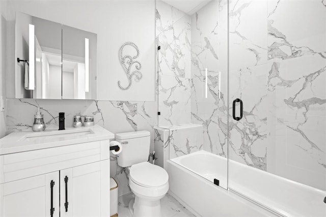 bathroom with marble look tile flooring, toilet, vanity, enclosed tub / shower combo, and tile walls