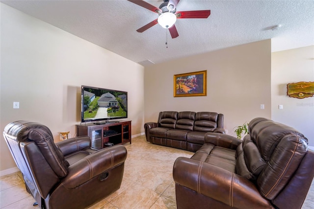 living room with a ceiling fan, a textured ceiling, light tile patterned flooring, and baseboards