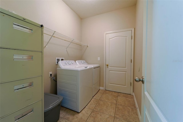laundry room featuring washing machine and dryer and light tile patterned floors