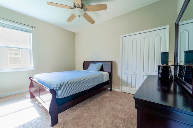 bedroom featuring light carpet, baseboards, and a ceiling fan