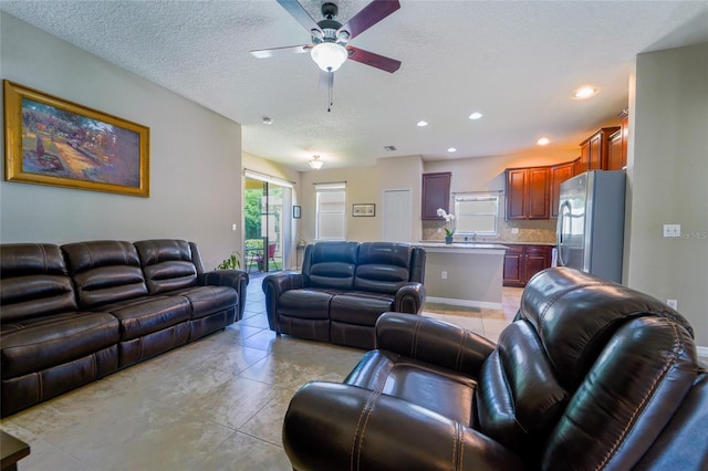 living room featuring a ceiling fan, light tile patterned flooring, recessed lighting, and a textured ceiling