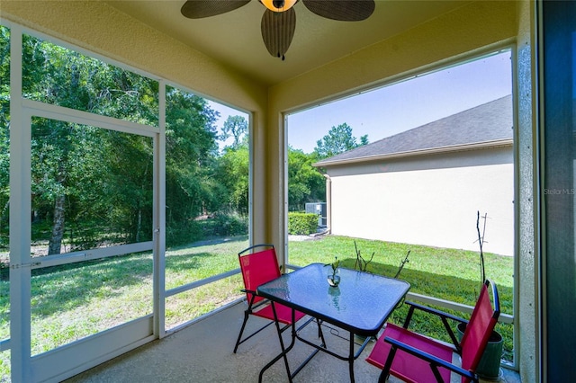sunroom with ceiling fan, outdoor dining area, and plenty of natural light