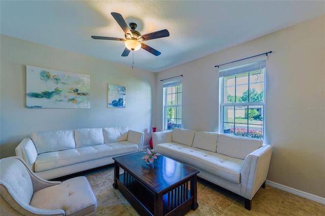 living area with a ceiling fan and baseboards